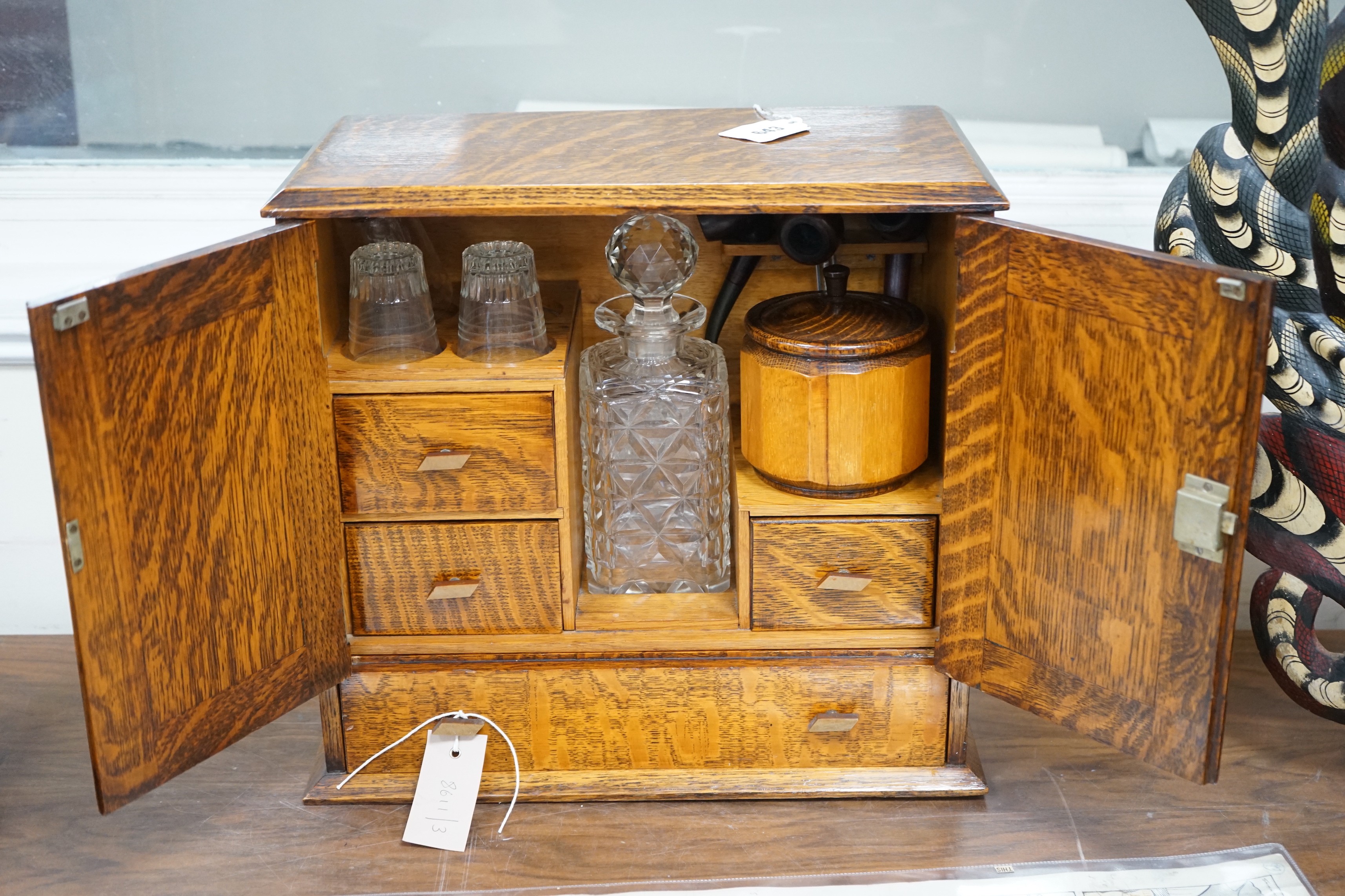 A 1920's oak smoker's / drinks box with decorative interior. 36cm tall, 39cm wide